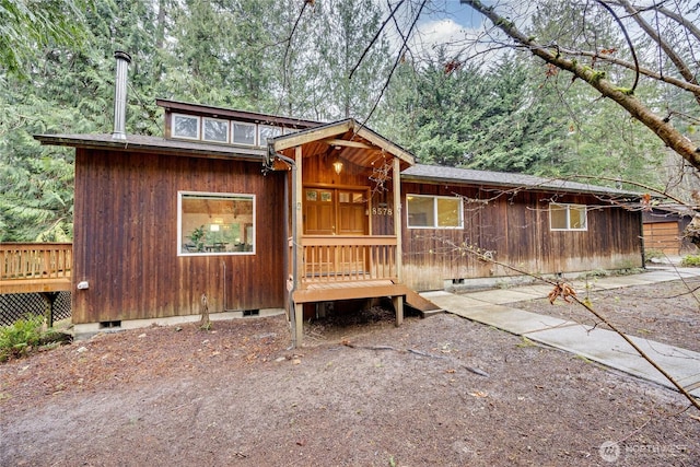 rustic home with crawl space and a view of trees