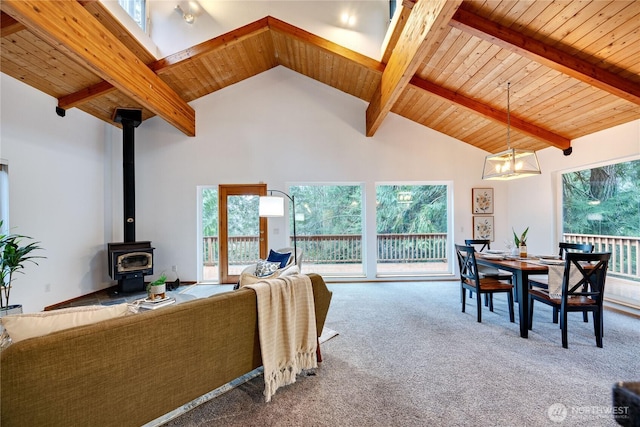 living room featuring high vaulted ceiling, wooden ceiling, beam ceiling, carpet, and a wood stove