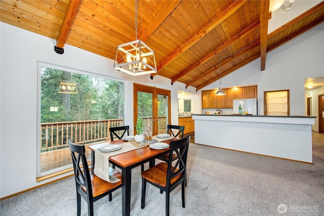 dining space with french doors, light colored carpet, beamed ceiling, and wooden ceiling