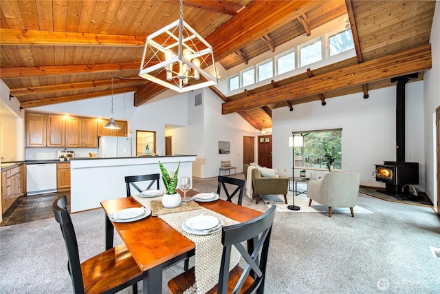 dining room featuring a notable chandelier, dark colored carpet, a wood stove, wooden ceiling, and beamed ceiling