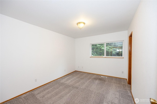 spare room with light carpet and baseboards