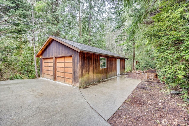 detached garage featuring a forest view