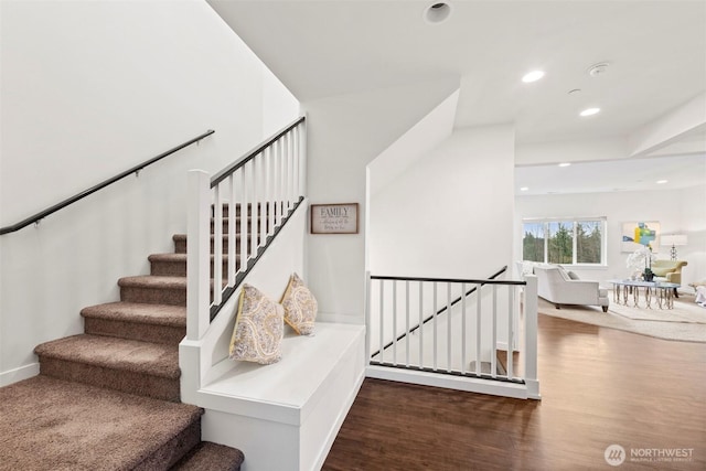 staircase featuring wood finished floors and recessed lighting