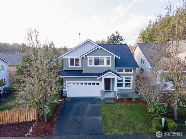 view of front of house featuring an attached garage, board and batten siding, fence, stone siding, and driveway