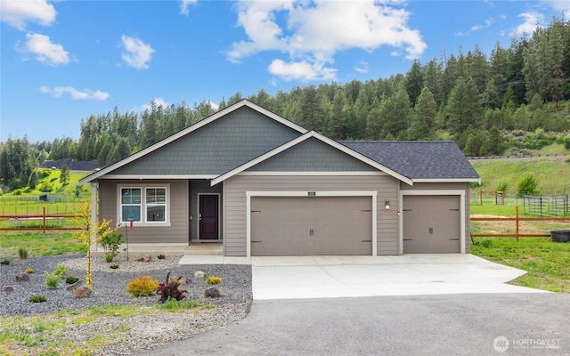 view of front of home with an attached garage, fence, concrete driveway, and roof with shingles