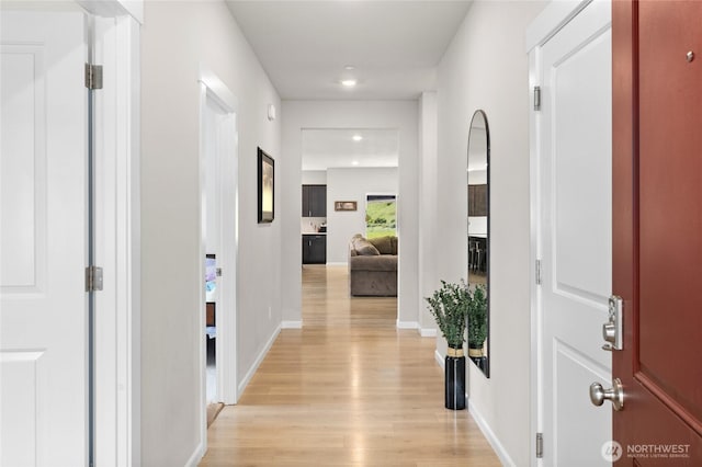 corridor with light wood-style floors, recessed lighting, and baseboards