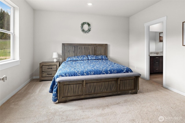 bedroom featuring baseboards, recessed lighting, a sink, and light colored carpet