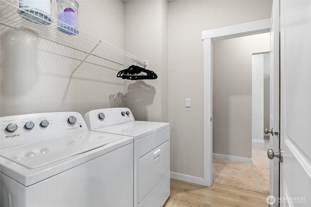 laundry room with light wood-type flooring, laundry area, baseboards, and washer and clothes dryer