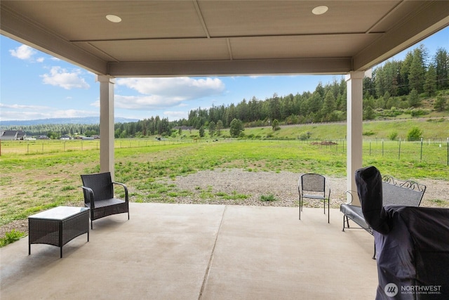 view of patio / terrace featuring a rural view and fence