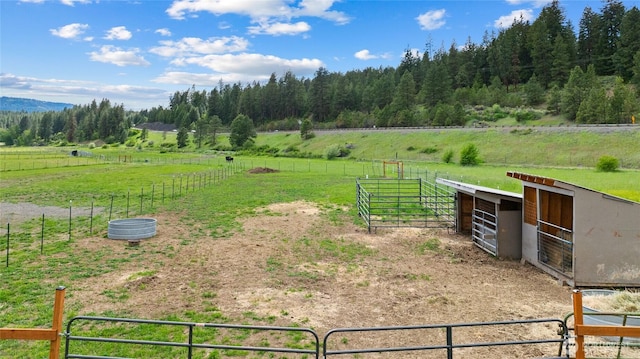 view of yard with an exterior structure, a rural view, and an outdoor structure