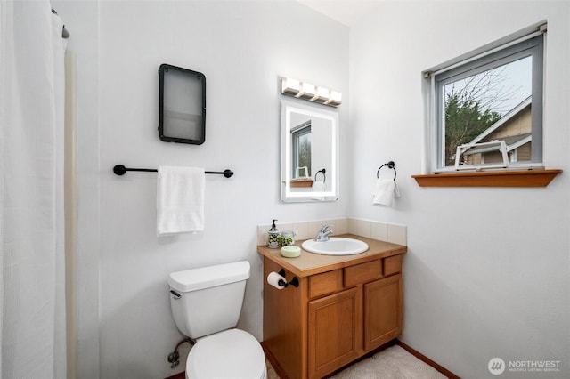 bathroom with toilet, curtained shower, and vanity