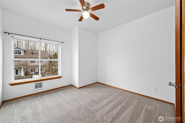 carpeted spare room with ceiling fan and baseboards