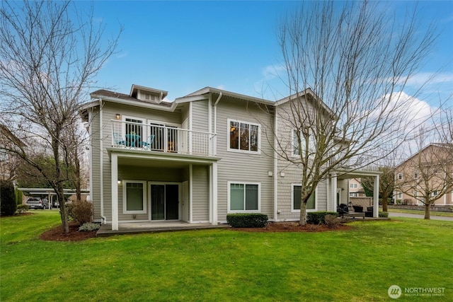 rear view of house featuring a patio area, a lawn, and a balcony