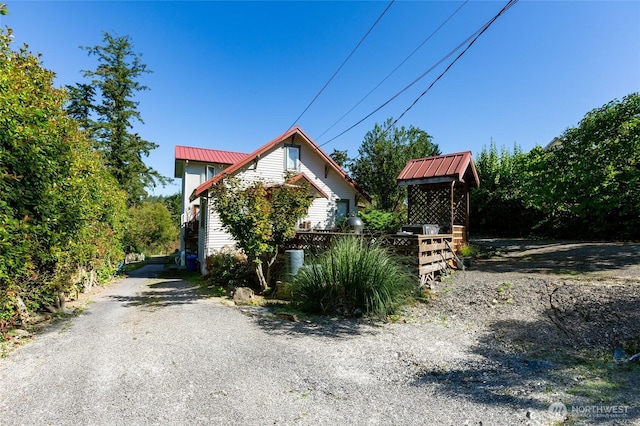 exterior space featuring driveway and metal roof