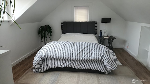 bedroom featuring vaulted ceiling, wood finished floors, and baseboards