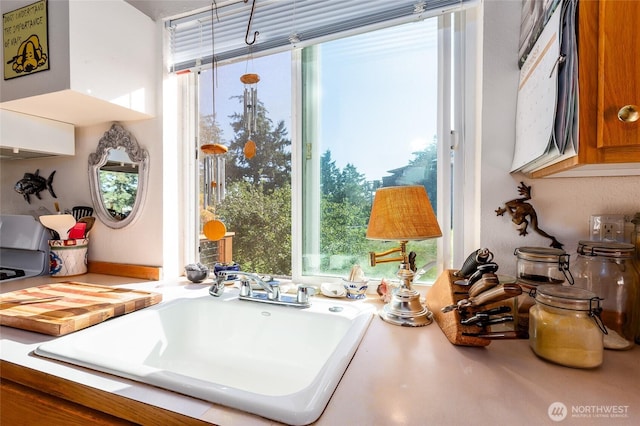 interior space with a sink, brown cabinets, and light countertops