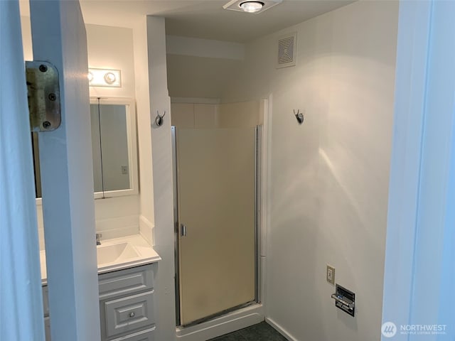 bathroom with visible vents, vanity, and a shower stall