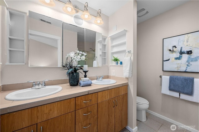 full bath featuring double vanity, a sink, toilet, and tile patterned floors