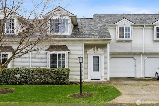 view of front of property with driveway, roof with shingles, a garage, and a front yard