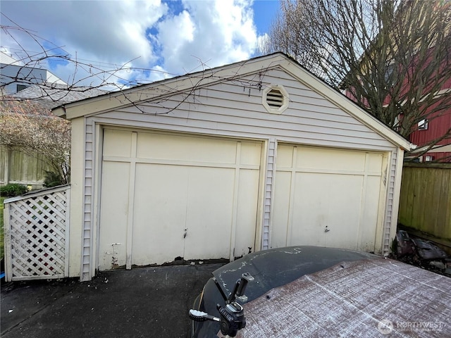 detached garage featuring fence