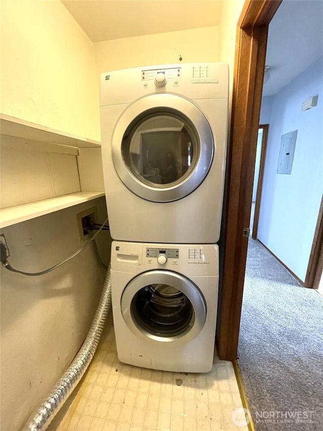 washroom with stacked washing maching and dryer, electric panel, laundry area, and light floors