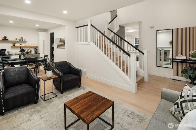 living room featuring light wood-style floors, recessed lighting, stairway, and baseboards