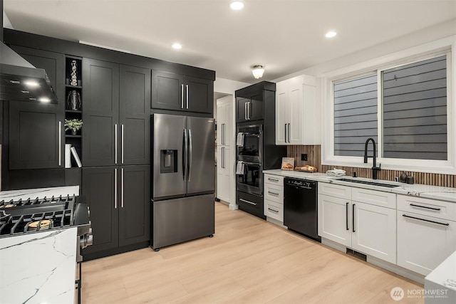 kitchen with light stone counters, black dishwasher, a sink, and stainless steel fridge with ice dispenser