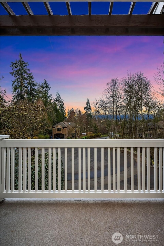 patio terrace at dusk with a balcony and a pergola