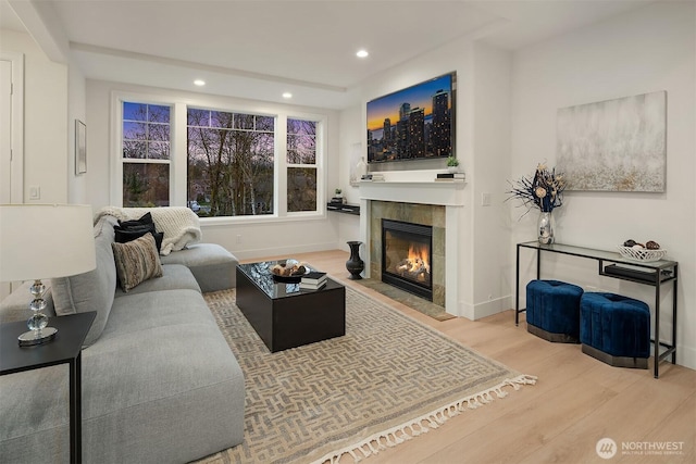 living area with a fireplace, baseboards, wood finished floors, and recessed lighting