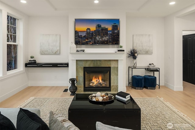 living room featuring recessed lighting, a tile fireplace, and wood finished floors