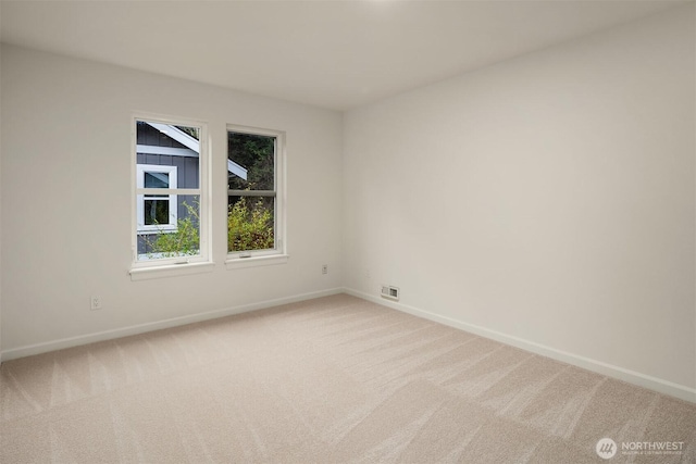 carpeted spare room with visible vents and baseboards