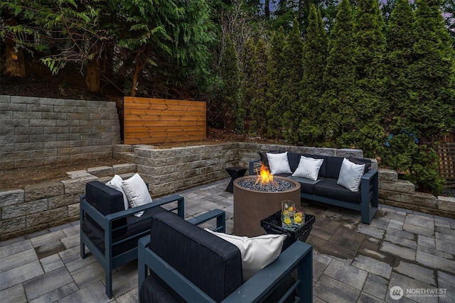 view of patio / terrace featuring fence and an outdoor living space with a fire pit