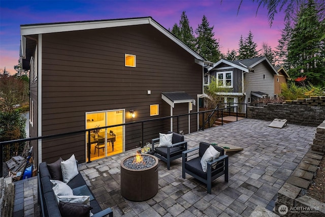 view of patio with an outdoor living space with a fire pit