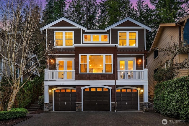 view of front of property featuring driveway, an attached garage, and french doors