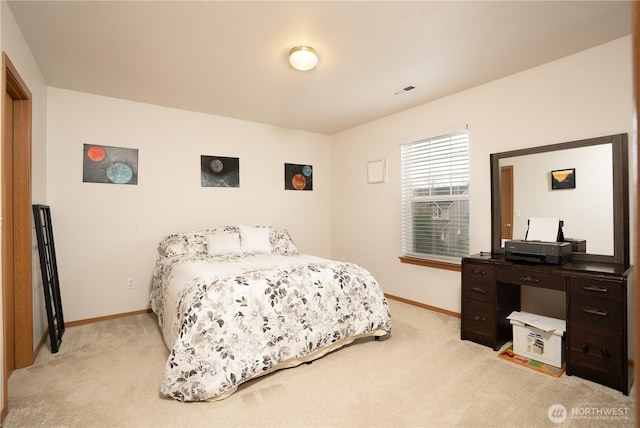 bedroom with baseboards and light colored carpet