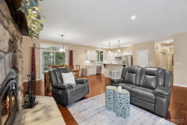 living room with recessed lighting, a fireplace, wood finished floors, and baseboards