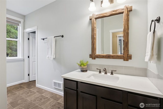 bathroom featuring baseboards, visible vents, and vanity