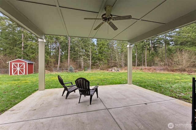 view of patio / terrace featuring a storage shed, a ceiling fan, and an outbuilding