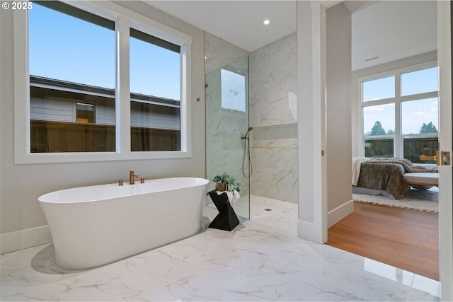 ensuite bathroom featuring ensuite bathroom, a freestanding tub, baseboards, marble finish floor, and a marble finish shower