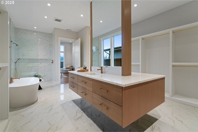 bathroom with marble finish floor, recessed lighting, visible vents, vanity, and a freestanding tub