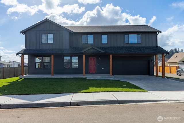 view of front of home featuring fence, a front lawn, board and batten siding, and concrete driveway