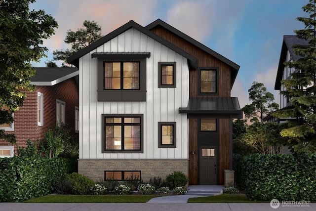 modern farmhouse featuring a standing seam roof, metal roof, board and batten siding, and brick siding