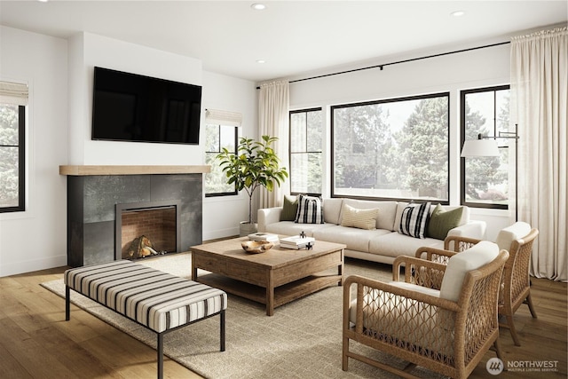 living room featuring a wealth of natural light, a tiled fireplace, wood finished floors, and recessed lighting