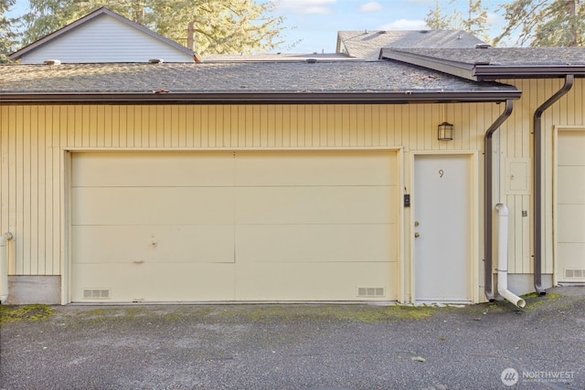 garage featuring visible vents and driveway