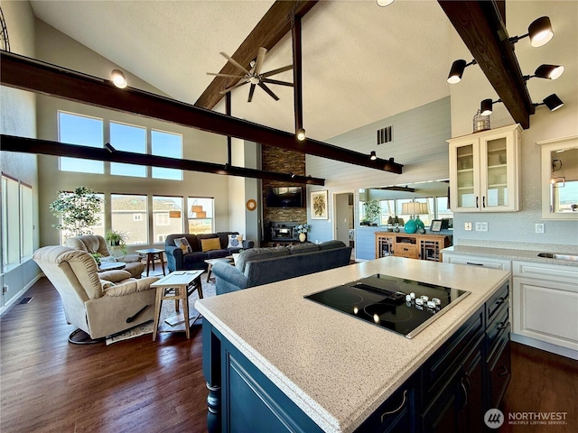 kitchen featuring dark wood-type flooring, black electric cooktop, visible vents, and open floor plan