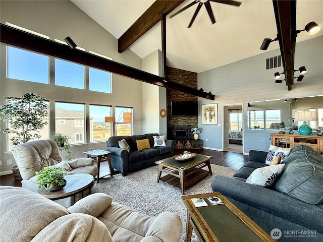 living room featuring visible vents, beamed ceiling, plenty of natural light, and wood finished floors