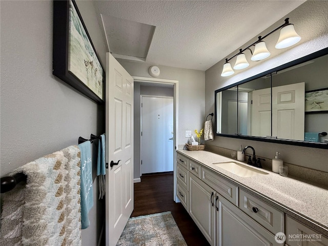 bathroom featuring a textured ceiling, vanity, and wood finished floors