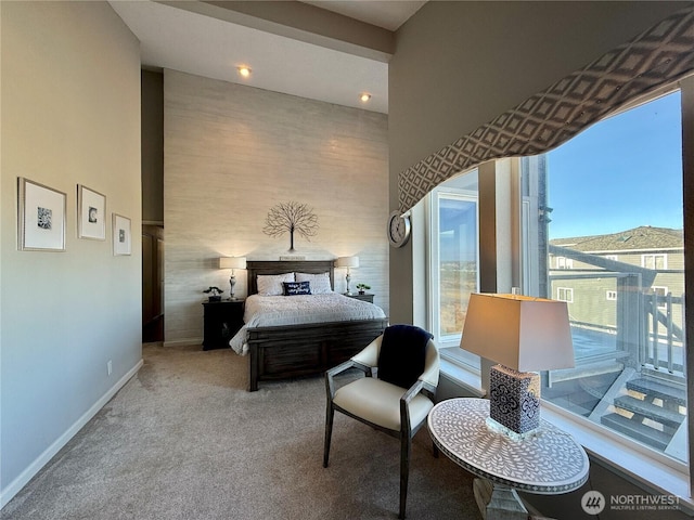 carpeted bedroom with an accent wall and baseboards