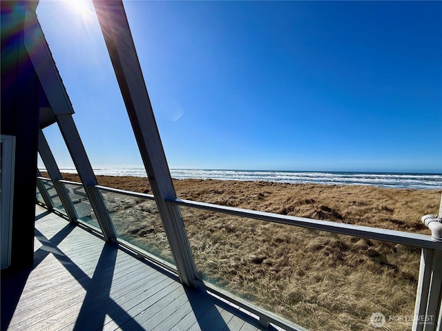 balcony featuring a beach view and a water view