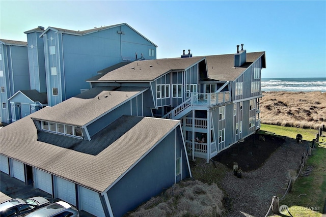 rear view of property featuring a garage and a water view